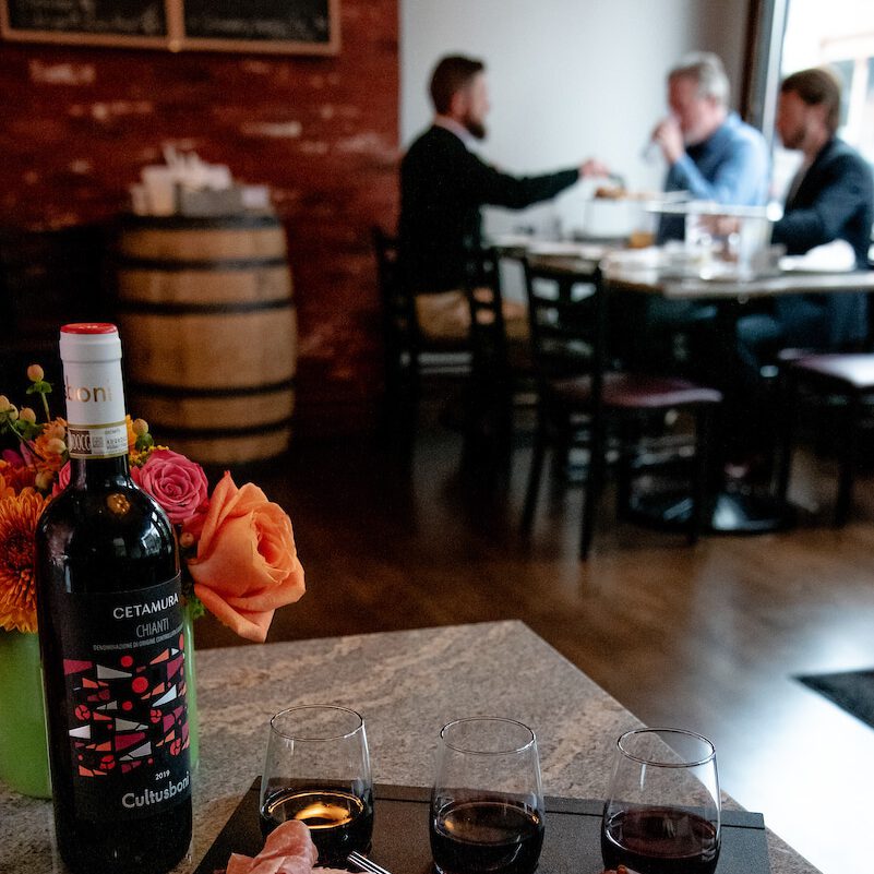 Cork N Crust Charcuterie board with wine flowers and guests in background